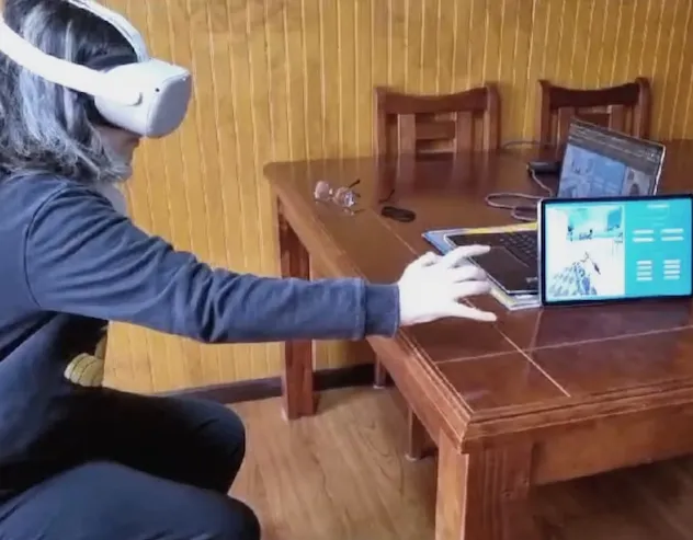 Ajedrez Captura Paciente usando visor de realidad virtual en una terapia de relajación con proyección de mano virtual, acompañada de un adulto mayor.